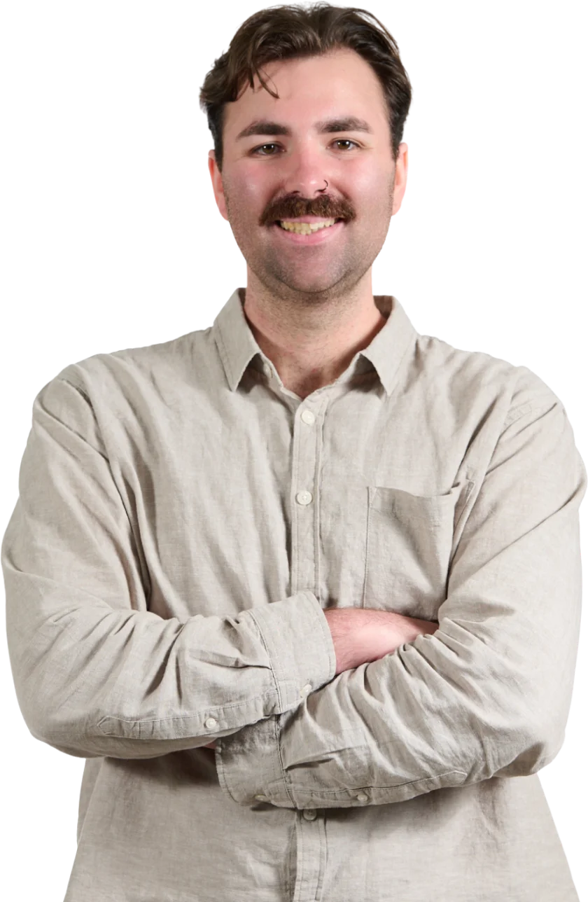 Benjamin smiling with his arms crossed in front of a bright cyan circle